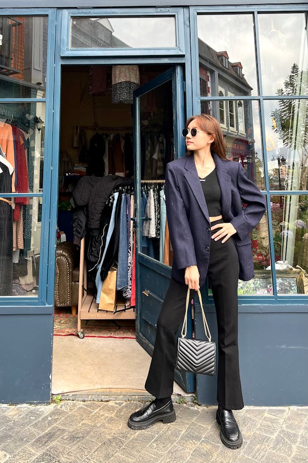 Visuel jeune femme moderne avec sac à main devant une boutique